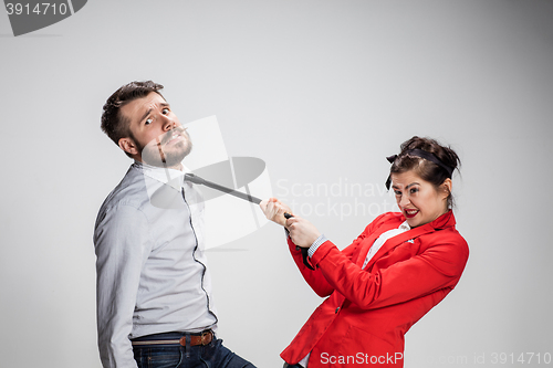 Image of Woman leading a man by his tie