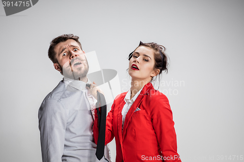 Image of Woman leading a man by his tie