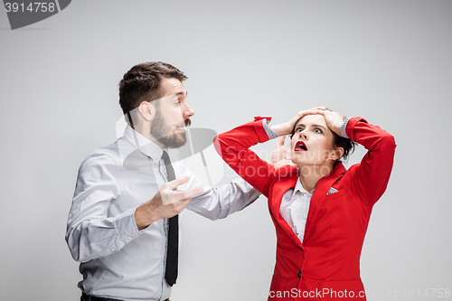 Image of The business man and woman conflicting on a gray background