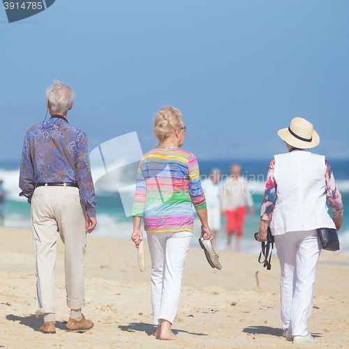 Image of Active seniors enjoying beach walk.