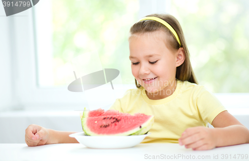 Image of Cute little girl is eating watermelon