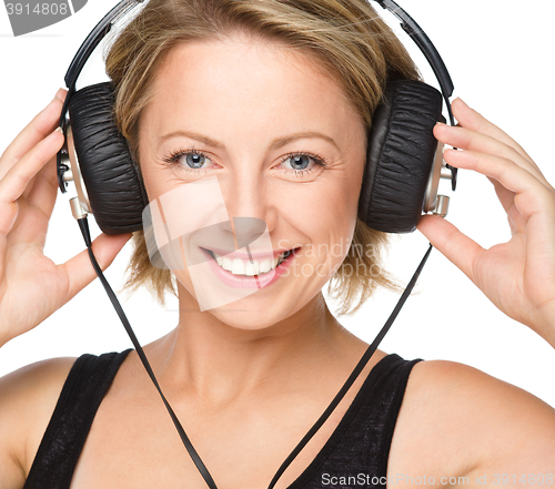 Image of Young woman enjoying music using headphones