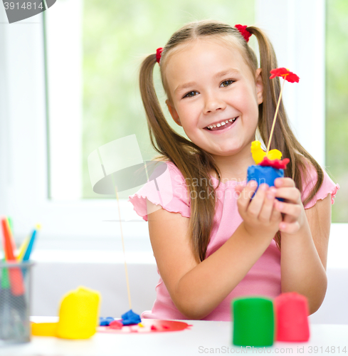 Image of Little girl is playing with plasticine