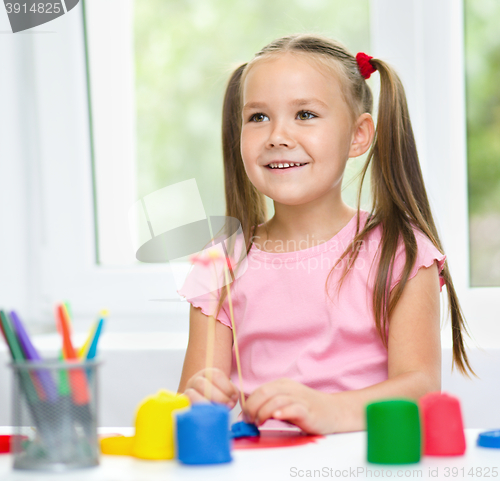 Image of Girl is having fun while playing with plasticine