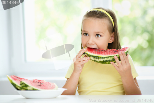 Image of Cute little girl is eating watermelon