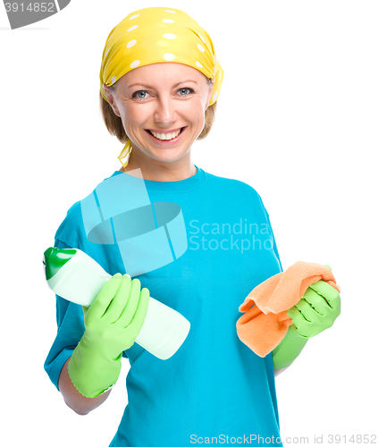 Image of Young woman with cleaning liquid and rag