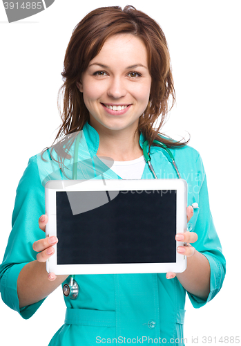 Image of Young cheerful doctor is showing her blank tablet