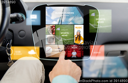 Image of close up of male hand media applications in car