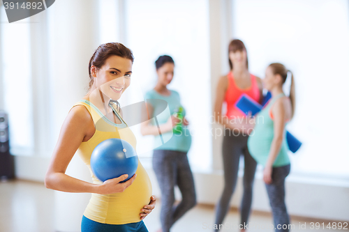 Image of happy pregnant woman with ball in gym