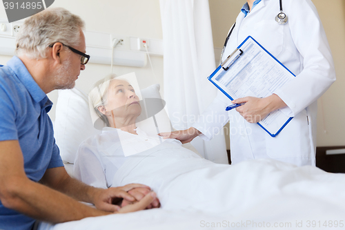 Image of senior woman and doctor with clipboard at hospital