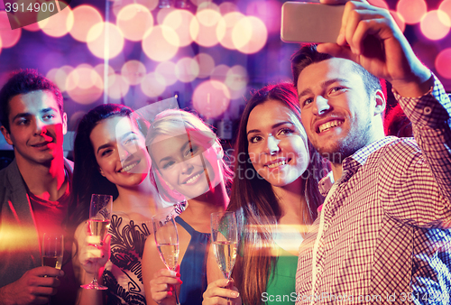 Image of friends with glasses and smartphone in club