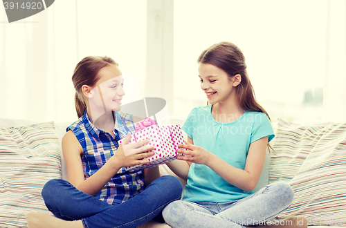 Image of happy little girls with birthday present at home