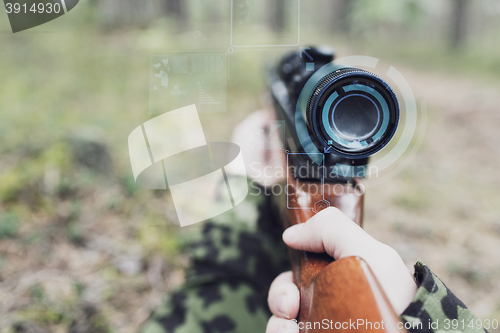 Image of close up of soldier or sniper with gun in forest