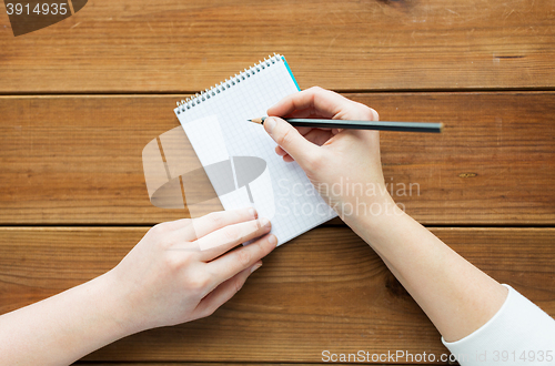 Image of close up of woman or student writing to notepad