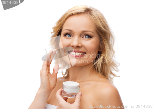 Image of happy woman applying cream to her face