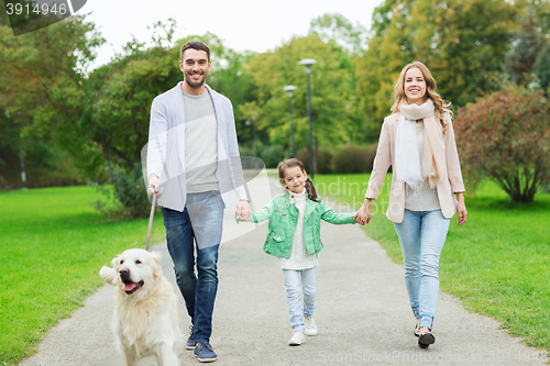 Image of happy family with labrador retriever dog in park