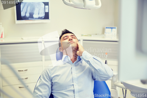 Image of man having toothache and sitting on dental chair