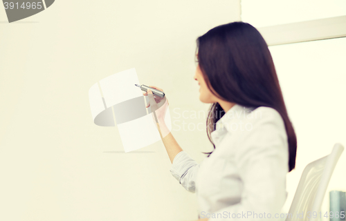 Image of happy woman with marker writing on whiteboard