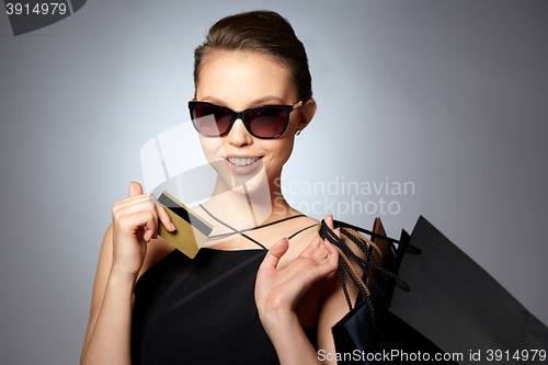 Image of happy woman with credit card and shopping bags