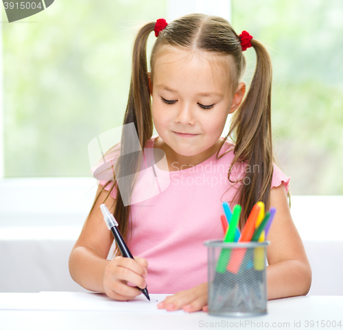 Image of Cute cheerful child drawing using felt-tip pen