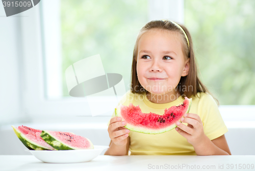 Image of Cute little girl is eating watermelon