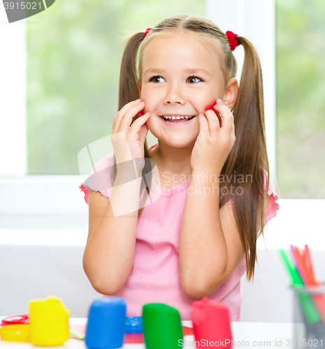 Image of Girl is having fun while playing with plasticine