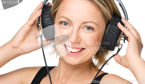 Image of Young woman enjoying music using headphones