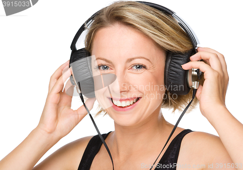 Image of Young woman enjoying music using headphones