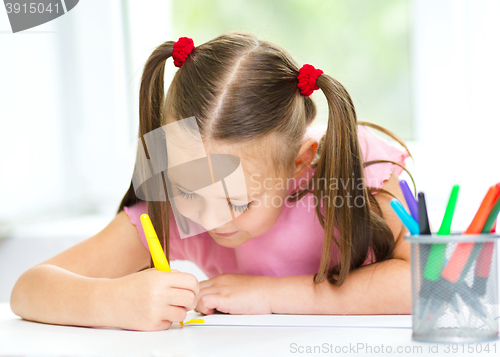 Image of Cute cheerful child drawing using felt-tip pen