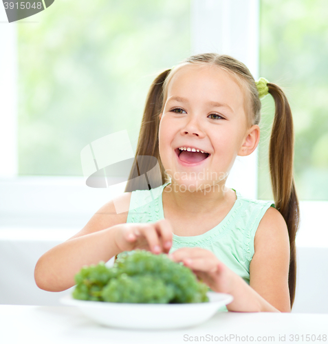 Image of Cute little girl is eating green grapes