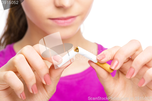 Image of Young woman is breaking a cigarette