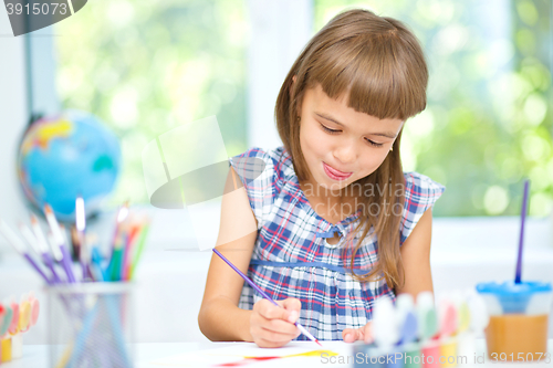 Image of Little girl is painting with gouache