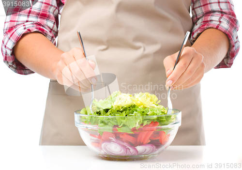 Image of Cook is mixing salad