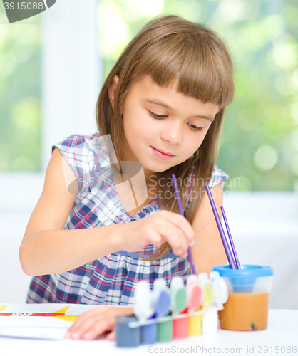 Image of Little girl is painting with gouache