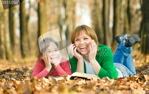 Image of Mother is reading book with her daughter