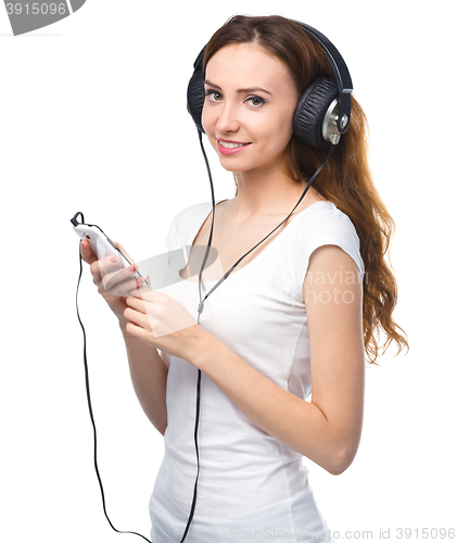 Image of Young woman enjoying music using headphones