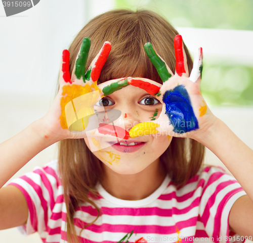 Image of Portrait of a cute girl playing with paints