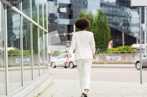 Image of african american businesswoman walking in city