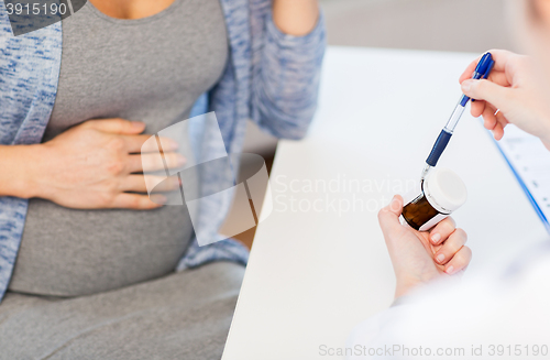 Image of close up of doctor showing pills to pregnant woman