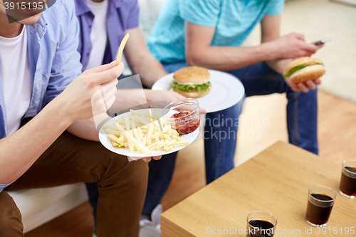 Image of close up of friends eating fast food at home