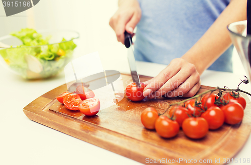 Image of close up of woman chopping tomatoes with knife