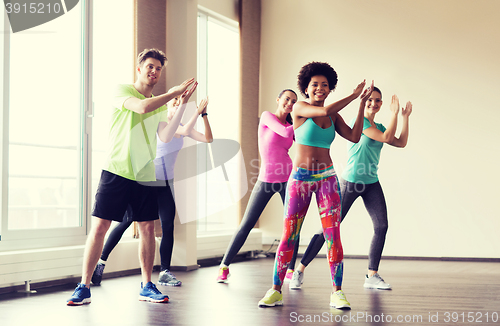 Image of group of smiling people dancing in gym or studio