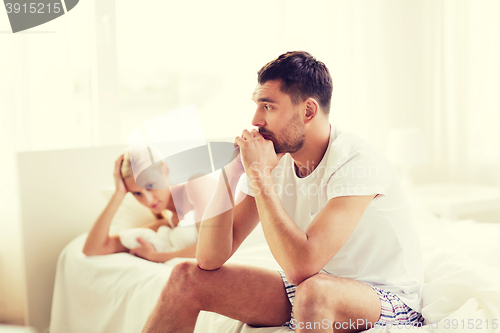 Image of unhappy couple having problems at bedroom