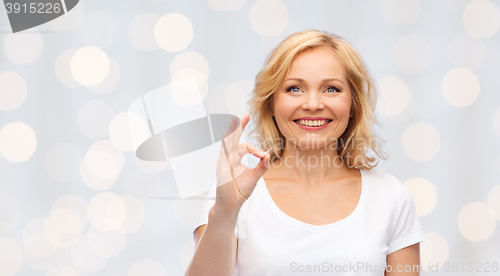 Image of happy woman in white t-shirt showing ok hand sign