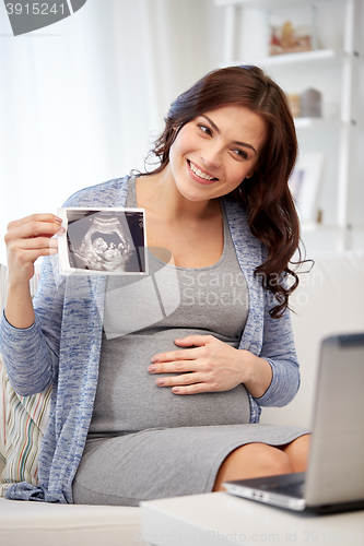 Image of happy pregnant woman with ultrasound image at home