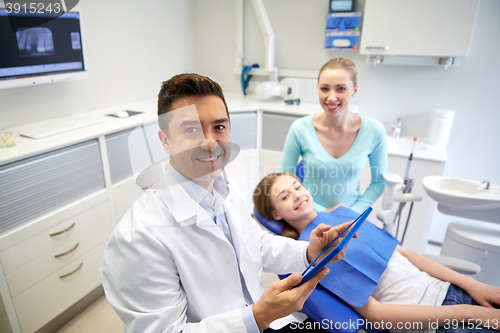 Image of dentist with tablet pc, patient girl and mother