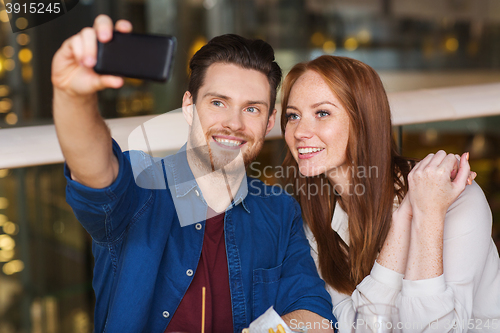 Image of couple taking selfie by smartphone at restaurant