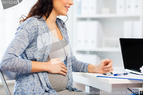 Image of close up of pregnant woman at medical office