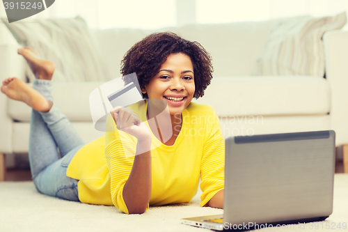 Image of happy african woman with laptop and credit card