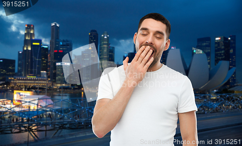 Image of yawning man over gray background